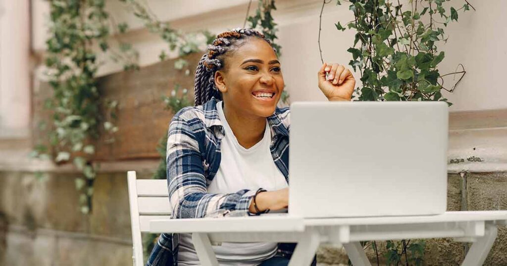 Woman sitting in front of her laptop smiling