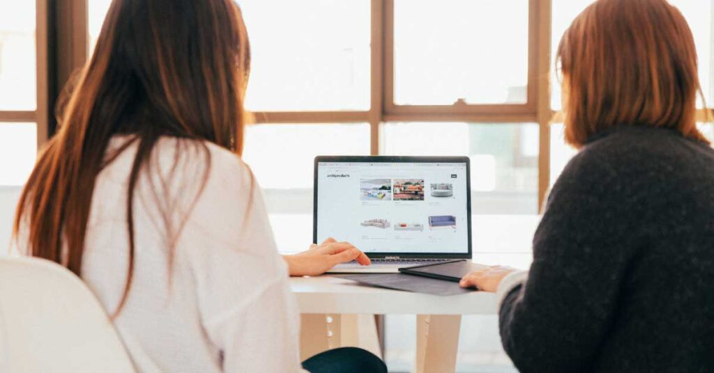 Image of two women creating website on computer using website builder